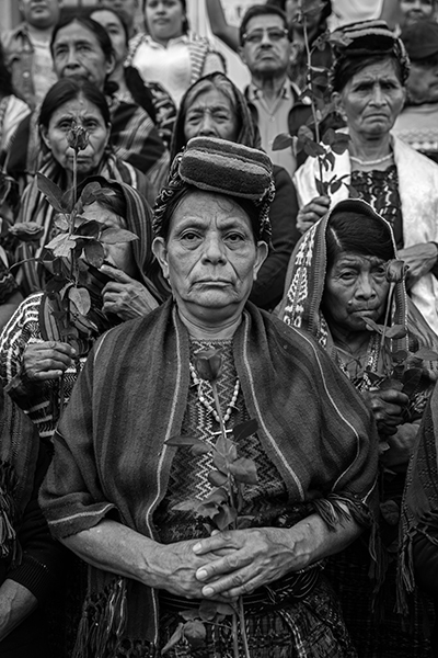 Title: The Trials of the Achi WomenCredit: &copy; Victor J. Blue, for The New York Times MagazineCaption: ​​Do&ntilde;a Paulina Ixpat&aacute; Alvarado stands with other Achi women outside a Guatemala City court. That afternoon, three ex-civil defense patrollers were found guilty of rape and crimes against humanity and sentenced to 40 years in prison each. Guatemala City, Guatemala, 30 May 2025.Story: For four decades, a group of Indigenous Maya Achi women in Rabinal lived in the same communities as the men who had raped them, sometimes as neighbors. Guatemala&rsquo;s civil war led to the genocide of thousands of Maya Achi people by the military and local state-backed paramilitary forces, who used sexual violence as a systematic weapon to subjugate Indigenous communities. In 2011, 36 women broke their silence, launching and winning a 14-year legal battle against their abusers. Their collective resilience is transforming a legacy of wartime impunity into a historic victory for justice.