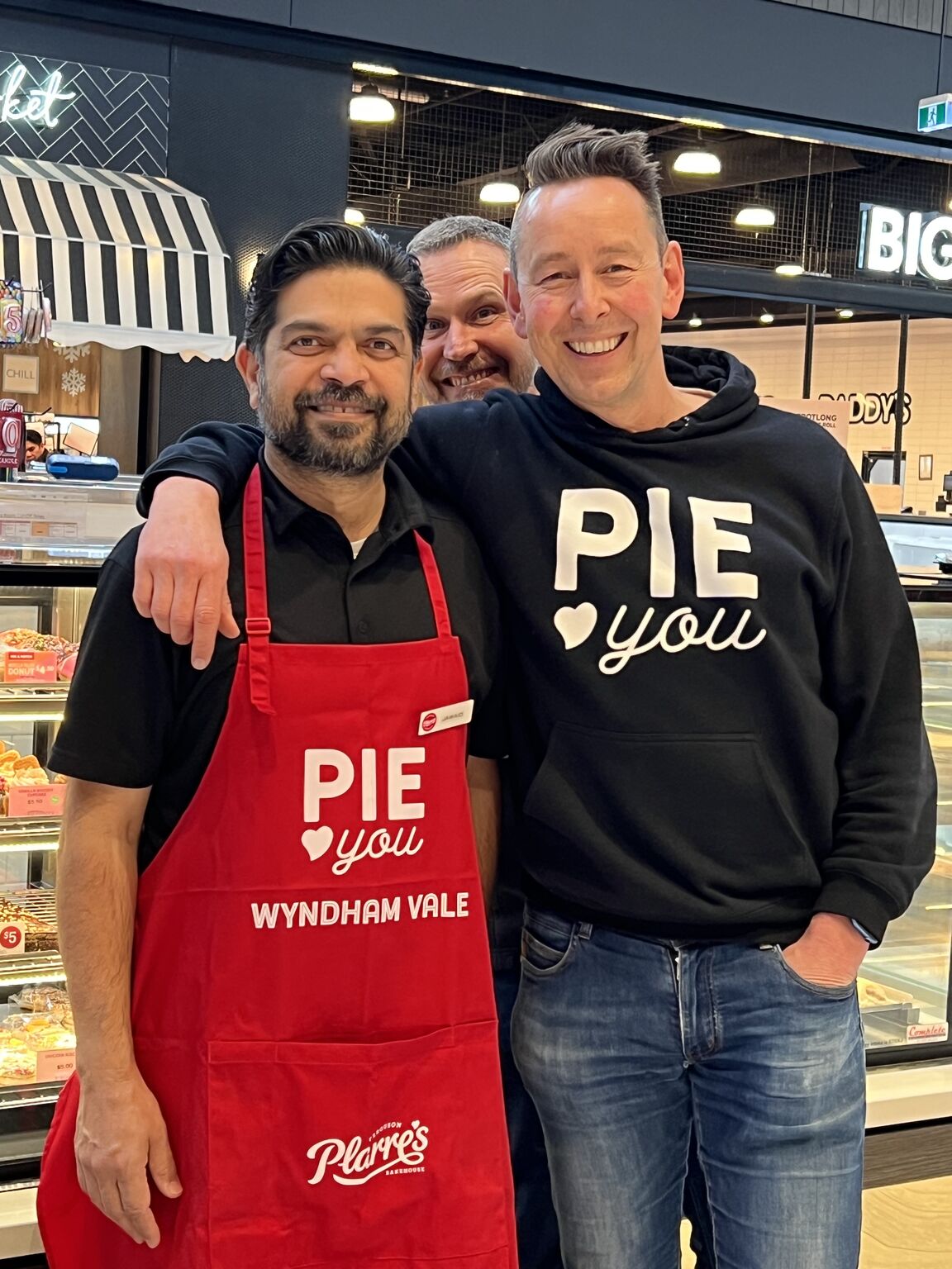 Saying 'pie love you ... Steve Plarre (right) with Jawaid, franchisee of Manor Lakes store, getting a laugh out of 'photo-bombing' COO Judd Sandwell. Image: Plarre Foods Group on Facebook.